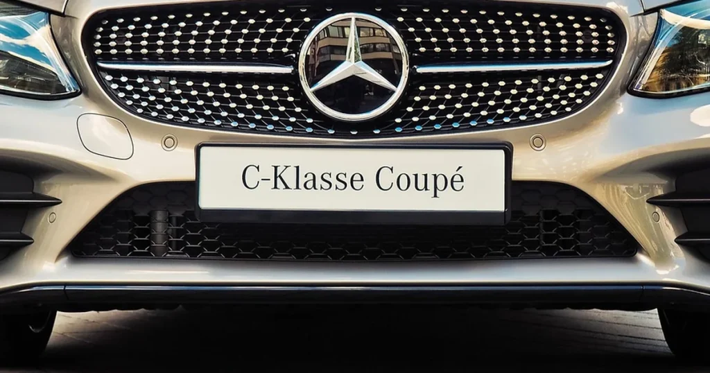 Face avant d'une Mercedes-Benz Classe C coupé, avec la calandre et l'étoile, sur une place de ville