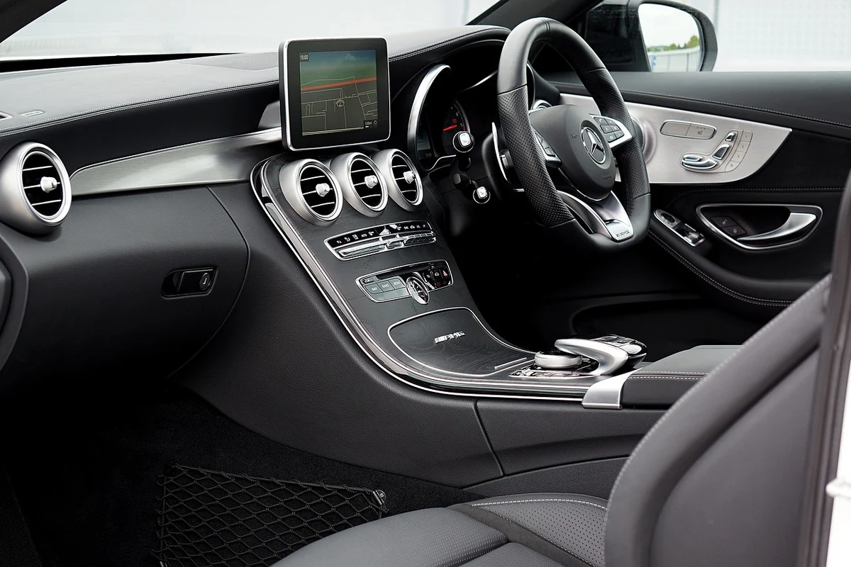 Habitacle d'un coupé Mercedes-Benz Classe C : volant, console centrale et sortie d'air