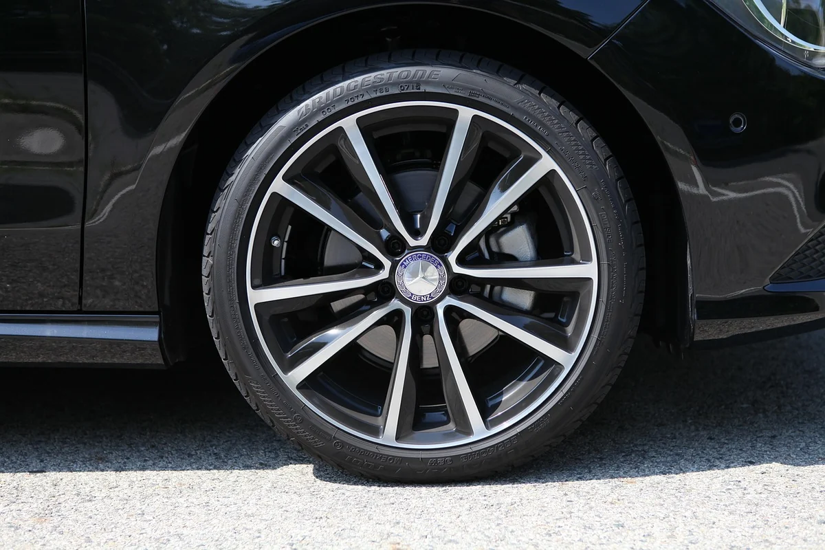 Roue en alliage d'une Mercedes-Benz vue de côté : le cache-moyeu occupe le centre de la jante, entouré des branches